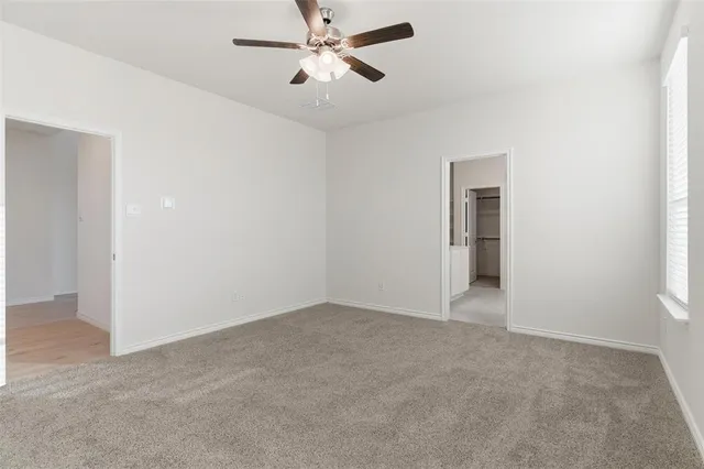 an empty room with closet and windows