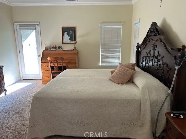 a spacious bedroom with a bed and a flat screen tv