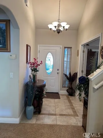 a living room with furniture a chandelier and a flat screen tv