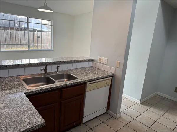 a kitchen with granite countertop a sink and a stove