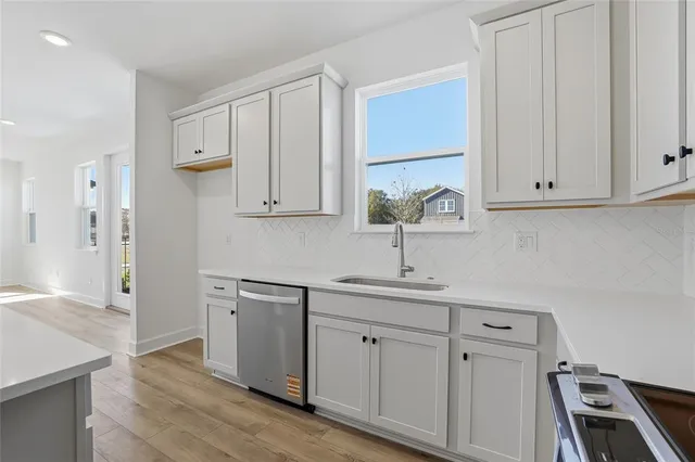 a kitchen with white cabinets appliances and a sink