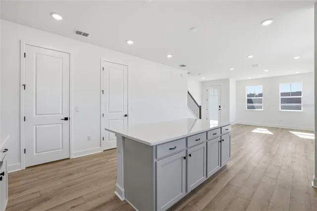 a kitchen with white cabinets appliances and a center island