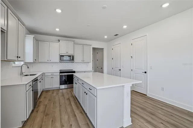 a kitchen with a sink stove and cabinets