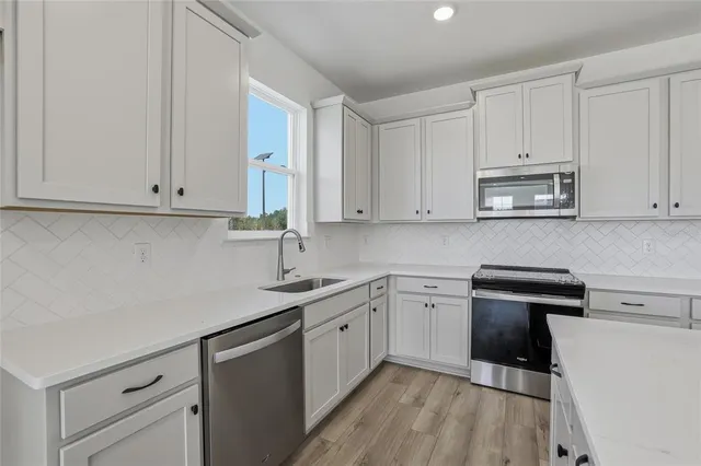 a kitchen with white cabinets and white appliances
