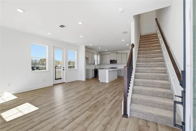 a view of a kitchen with wooden floor and stairs