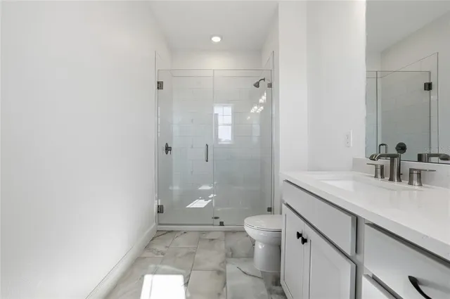 a bathroom with a granite countertop sink mirror vanity and toilet
