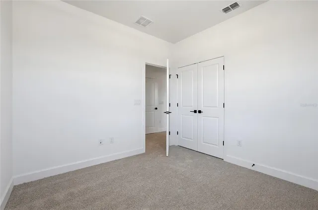 an empty room with white wall and shower
