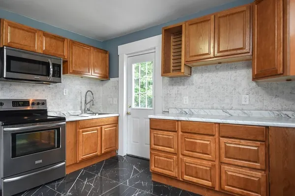 a kitchen with stainless steel appliances granite countertop a sink a stove a microwave and cabinets