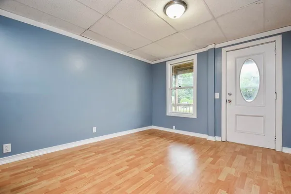 a view of empty room with window and bathroom