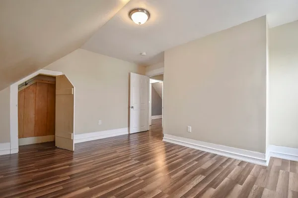 an empty room with wooden floor and closet