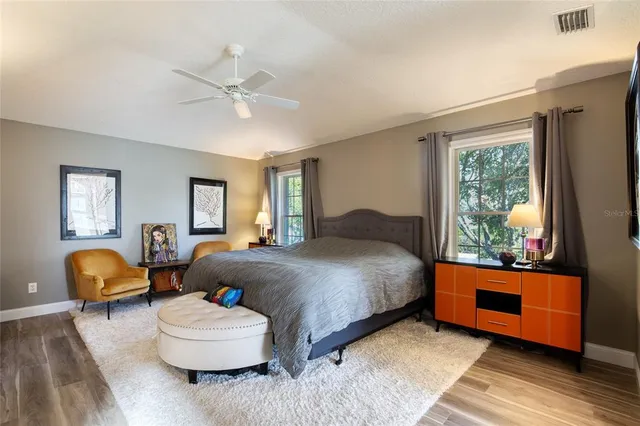 a view of a backyard with potted plants and large tree