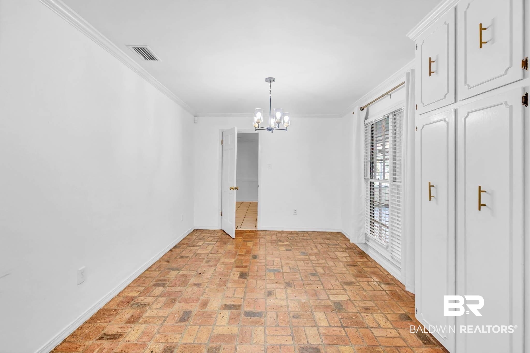 309 West Brandy Run Road Mobile, AL 36608 - Photo 25 of 100 Unfurnished dining area featuring crown molding, brick flooring, and a chandelier