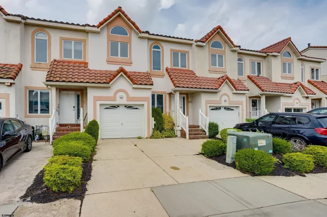 a front view of a house with a yard and potted plants