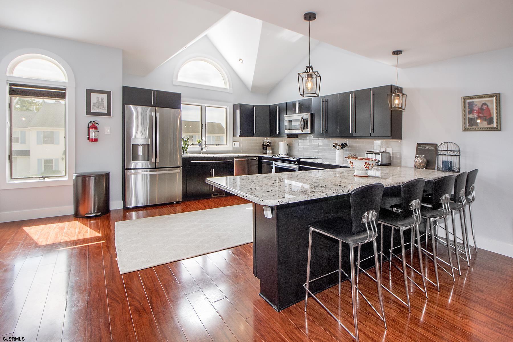 317 Gull Cove Brigantine, NJ 08203 - Photo 7 of 39 a kitchen with stainless steel appliances granite countertop a table chairs stove and refrigerator