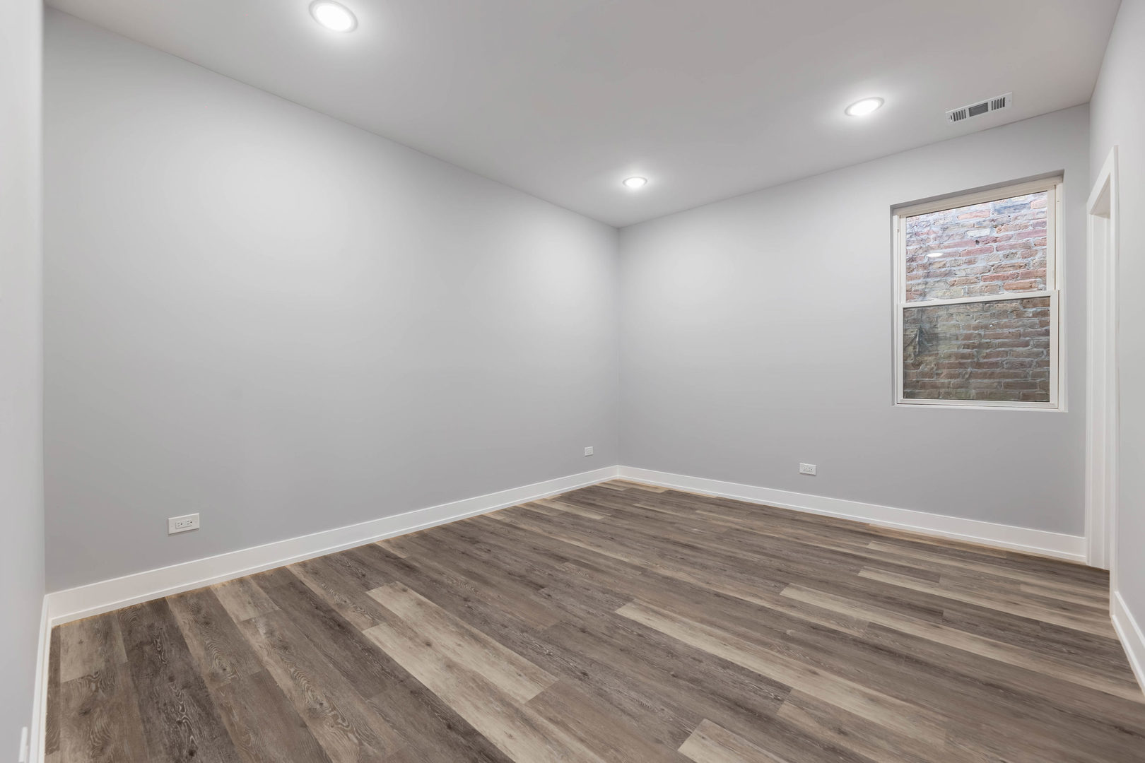 5809 South Indiana Avenue, Unit 2 Chicago, IL 60637 - Photo 17 of 18 an empty room with wooden floor and windows