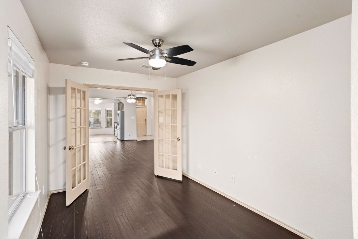 409 Lydia Lane Thrall, TX 76578 - Photo 14 of 39 a view of an empty room with wooden floor and a ceiling fan