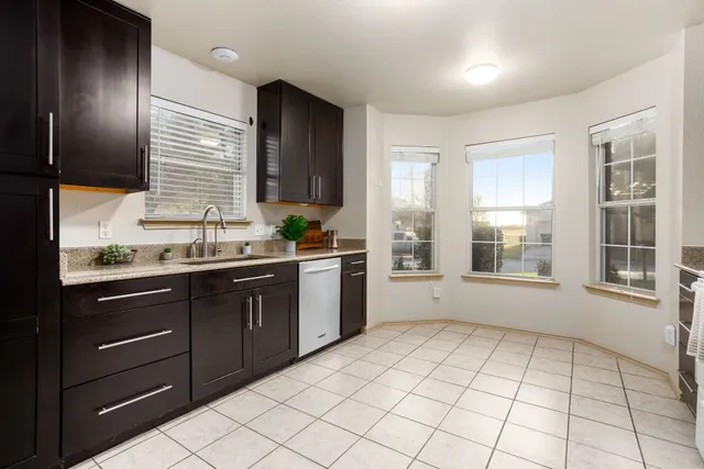 an empty room with chandelier fan and windows