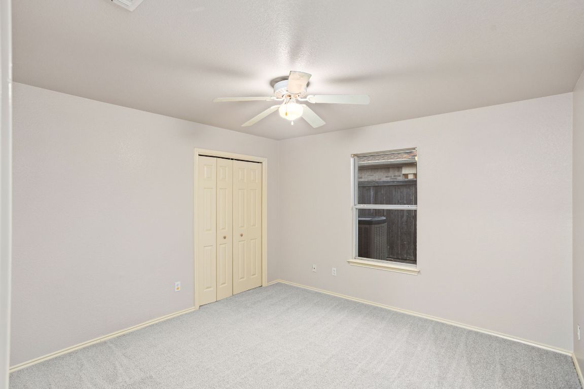 409 Lydia Lane Thrall, TX 76578 - Photo 29 of 39 an empty room with chandelier fan and windows
