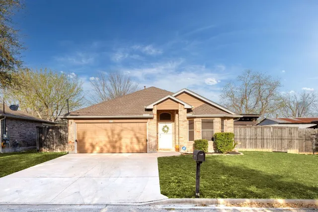 a living room with furniture a chandelier and wooden floor