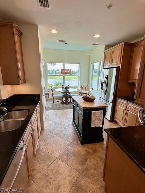 9221 Quartz Lane, Unit 9102 Naples, FL 34120 - Photo 13 of 19 Kitchen with stainless steel appliances, a textured ceiling, a sink, visible vents, and a notable chandelier