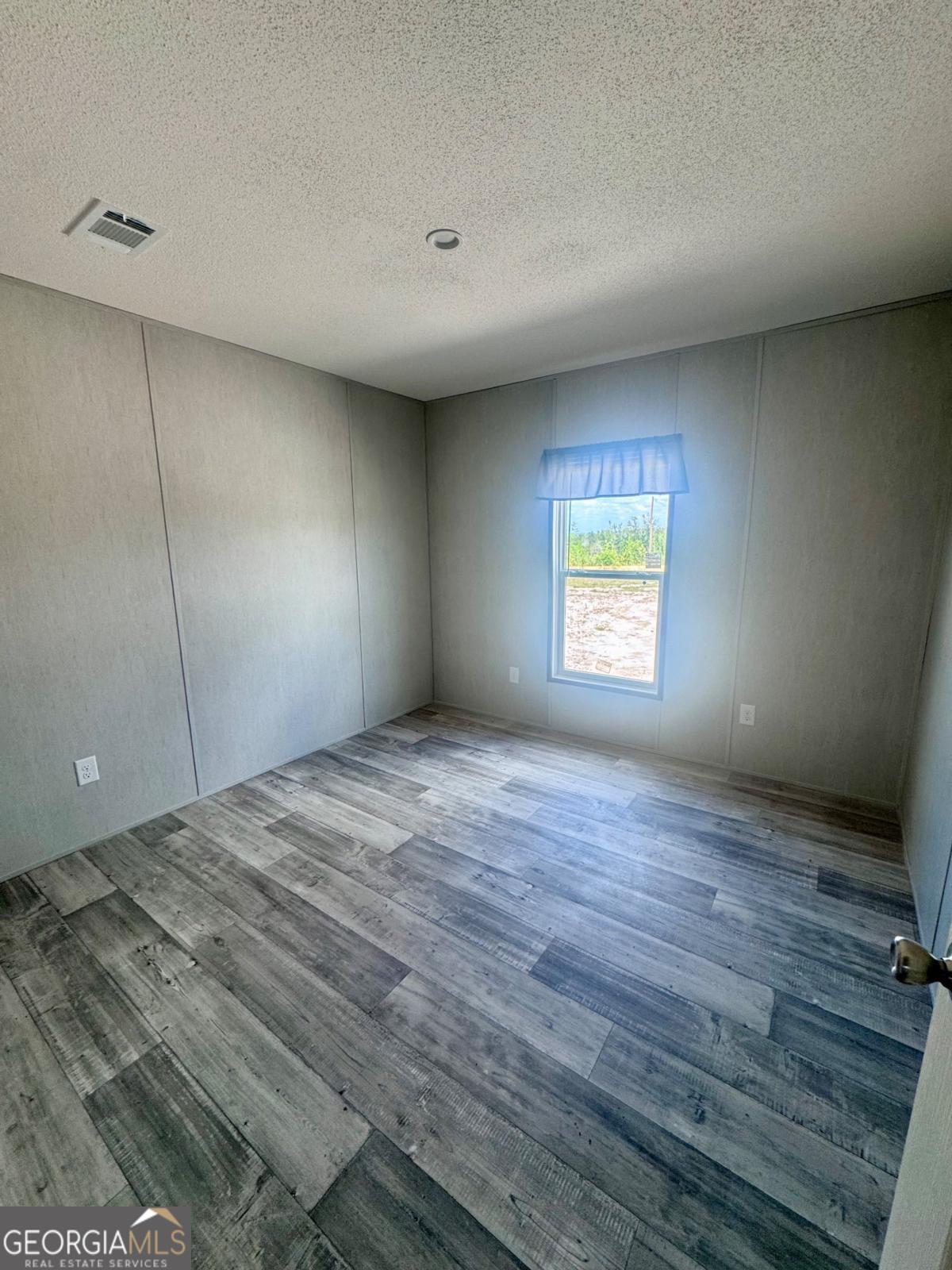 67 Long Leaf Road Hazlehurst, GA 31539 - Photo 13 of 17 a view of empty room with wooden floor and fan