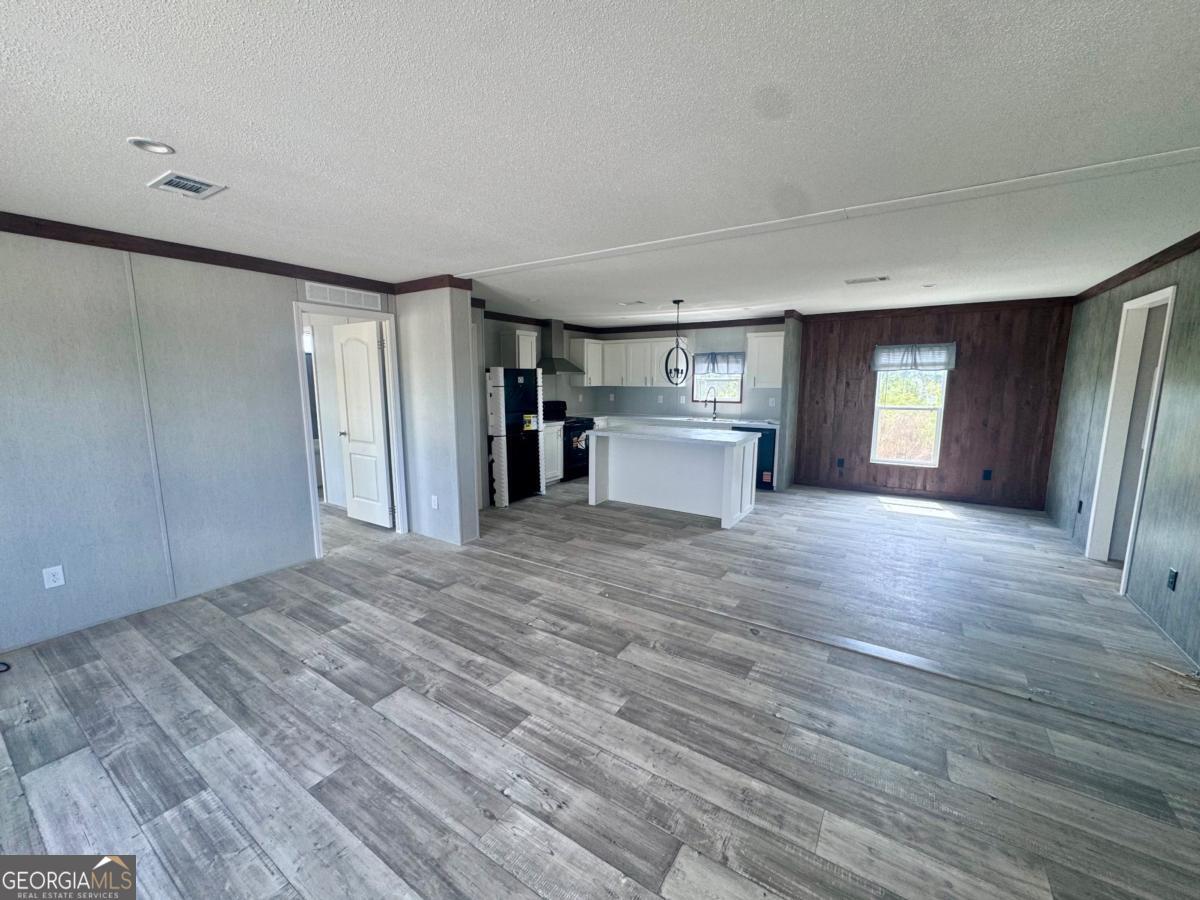 67 Long Leaf Road Hazlehurst, GA 31539 - Photo 5 of 17 a view of empty room with wooden floor and fan