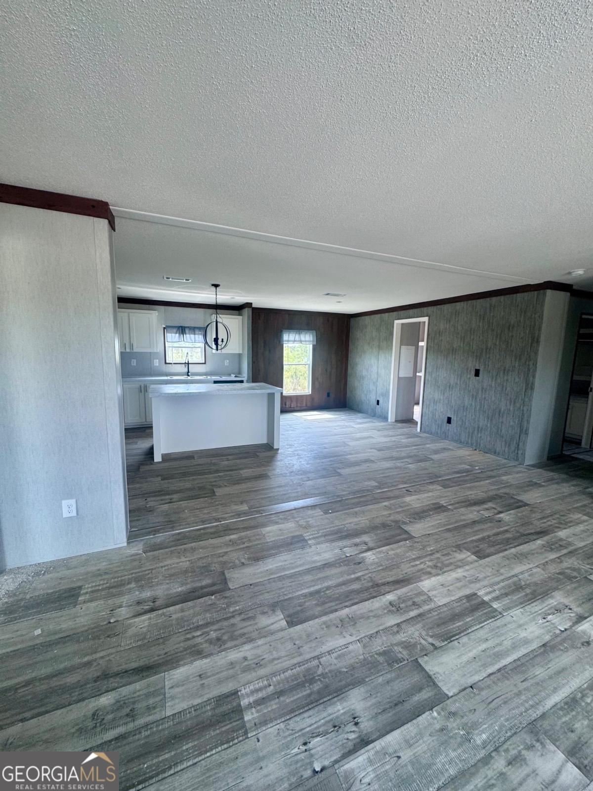 67 Long Leaf Road Hazlehurst, GA 31539 - Photo 6 of 17 a view of a kitchen with kitchen island a sink wooden floor and a refrigerator