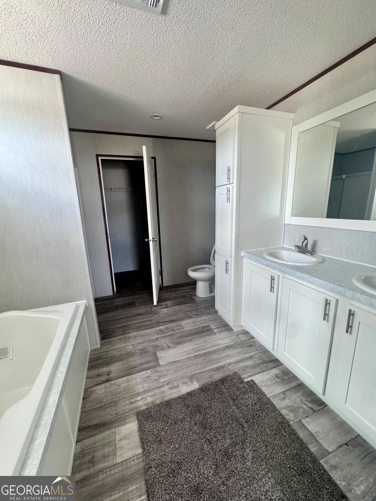 67 Long Leaf Road Hazlehurst, GA 31539 - Photo 9 of 17 a bathroom with a sink a mirror and a bathtub