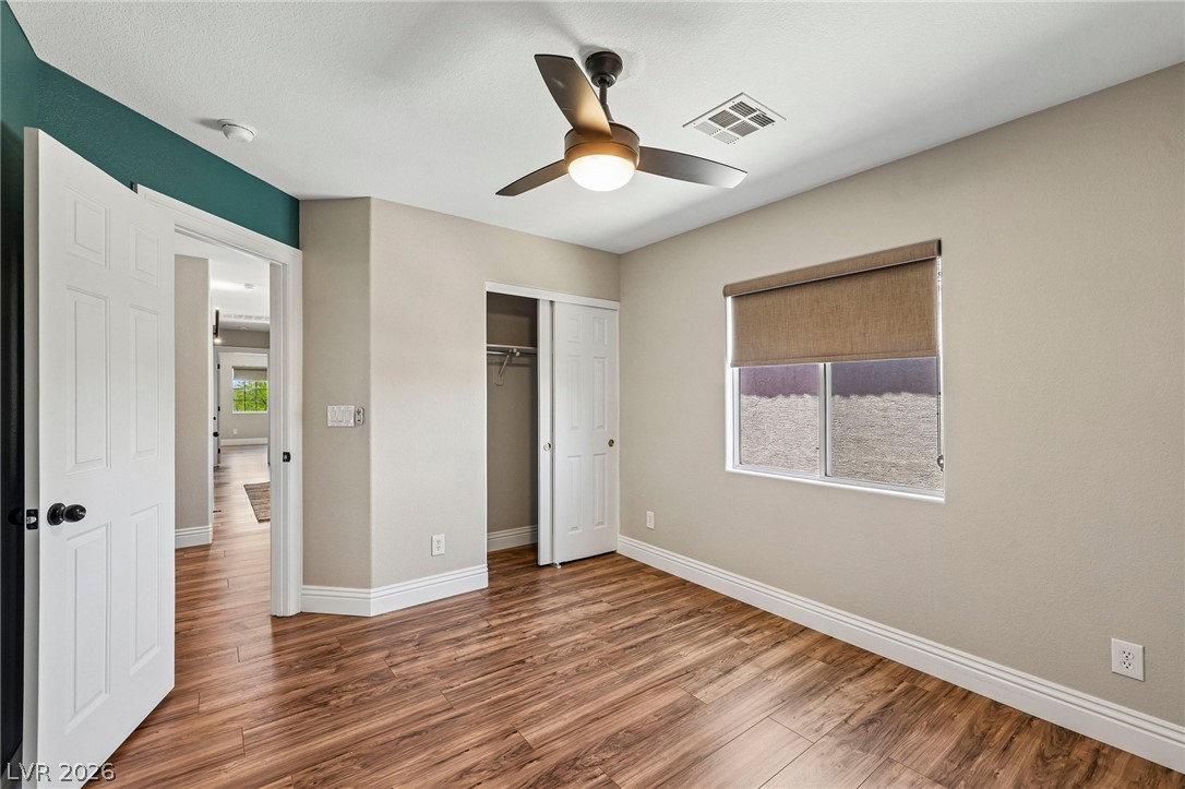 1176 Butternut Ranch Court Henderson, NV 89052 - Photo 21 of 60 A comfortable bedroom with rich wood flooring and a modern ceiling fan for optimal airflow.
