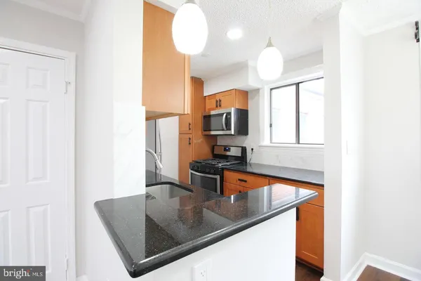 a kitchen with a sink a counter top space cabinets and stainless steel appliances
