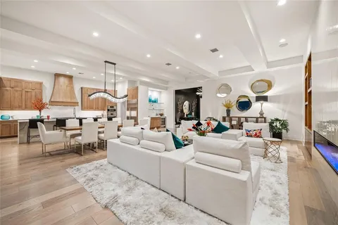 a kitchen with stainless steel appliances granite countertop a stove top oven a sink and white cabinets with wooden floor