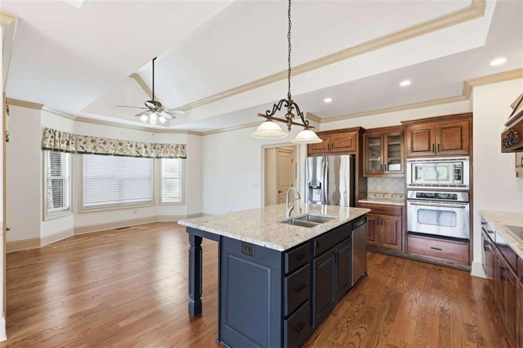 5264 Laurel Circle Gainesville, GA 30506 - Photo 16 of 47 a large kitchen with a center island wooden floor stainless steel appliances and a chandelier