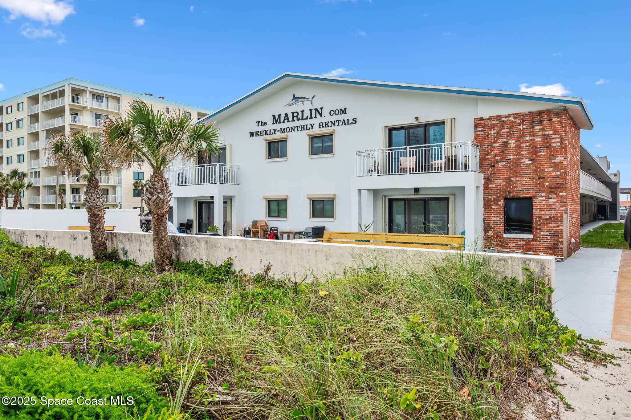 Undisclosed Address Cocoa Beach, FL 32931 - Photo 19 of 23 a front view of a building with a garden