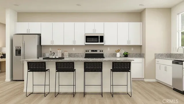 a kitchen with stainless steel appliances a stove a sink cabinets and a refrigerator