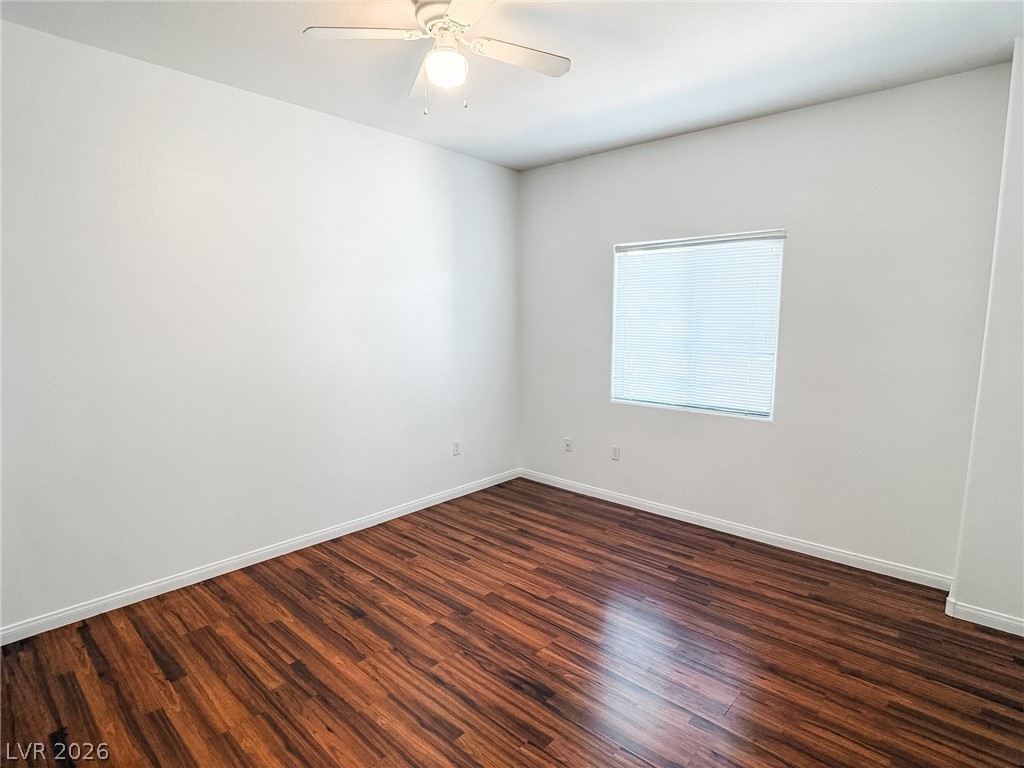 7701 West Robindale Road, Unit 110 Las Vegas, NV 89113 - Photo 9 of 21 Rich hardwood-style flooring and a window with blinds define this versatile interior space.
