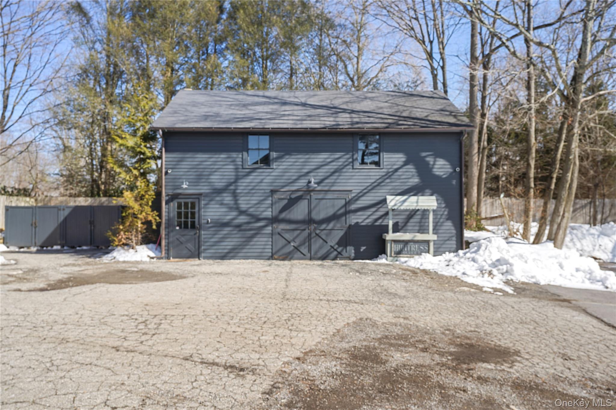 259 Westchester Avenue Pound Ridge, NY 10576 - Photo 3 of 21 a view of a wooden house with a wooden fence