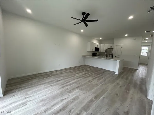 a view of a kitchen with a sink and wooden floor
