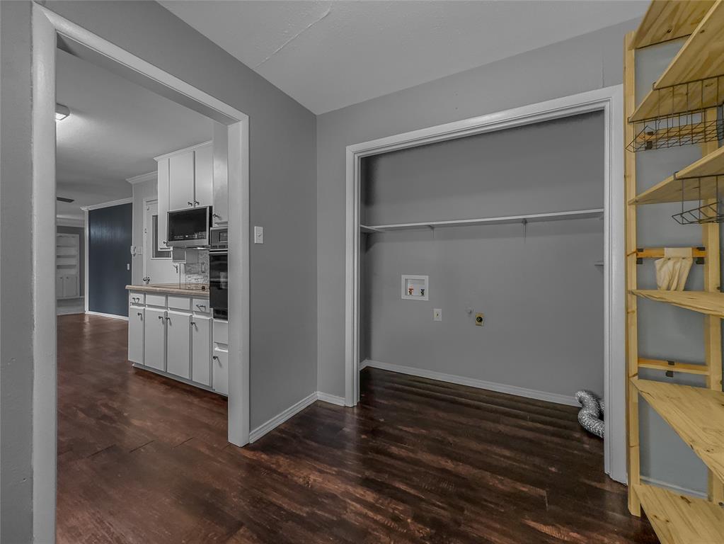 220 Cooper Drive Hurst, TX 76053 - Photo 11 of 27 a kitchen with white cabinets and wooden floors