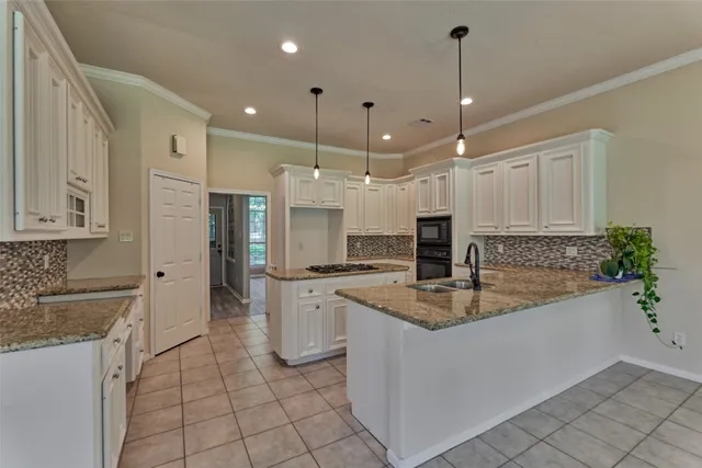 a kitchen with stainless steel appliances granite countertop a sink a stove and a refrigerator