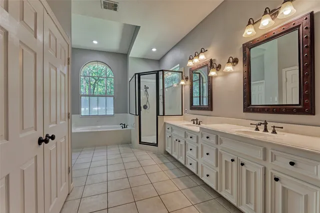 an empty room with wooden floor chandelier fan and windows