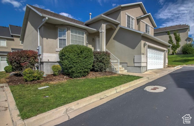 1154 South 1430th Street East Provo, UT 84606 - Photo 1 of 1 Traditional home featuring stucco siding, a front lawn, and a garage