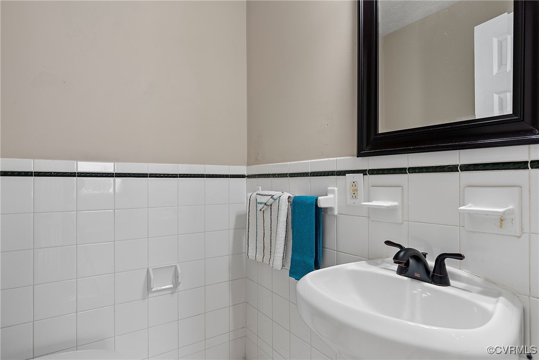 975 Windyknight Road Montpelier, VA 23192 - Photo 24 of 38 Bathroom with a textured ceiling, sink, and tile w