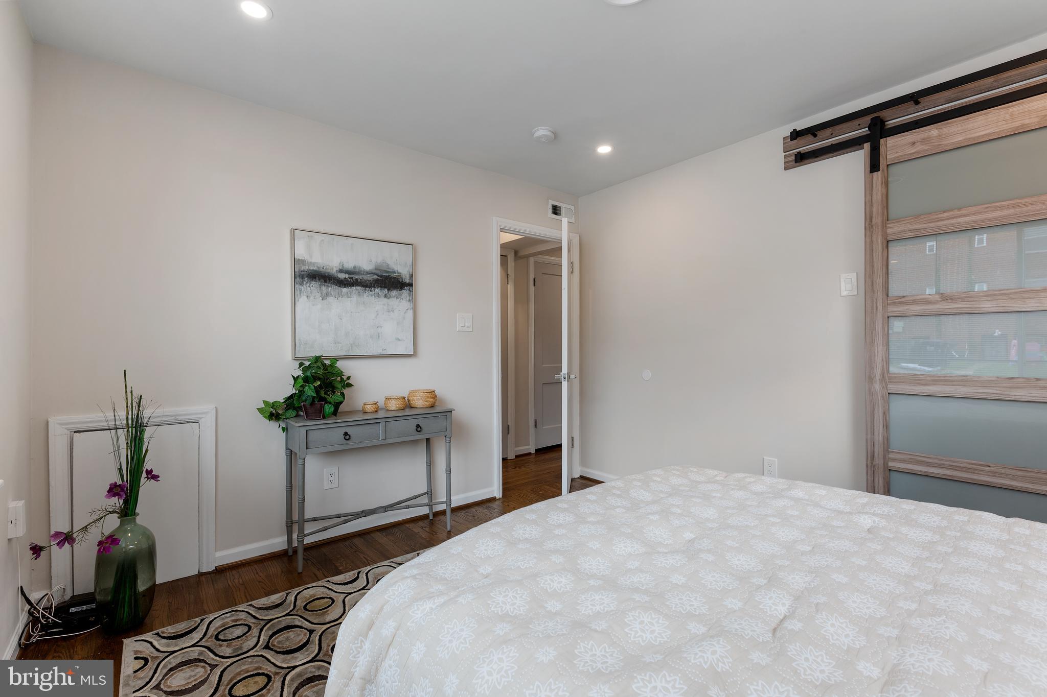53 Victor Street Northeast, Unit 1 Washington, DC 20011 - Photo 13 of 18 a bedroom with a bed and a dresser