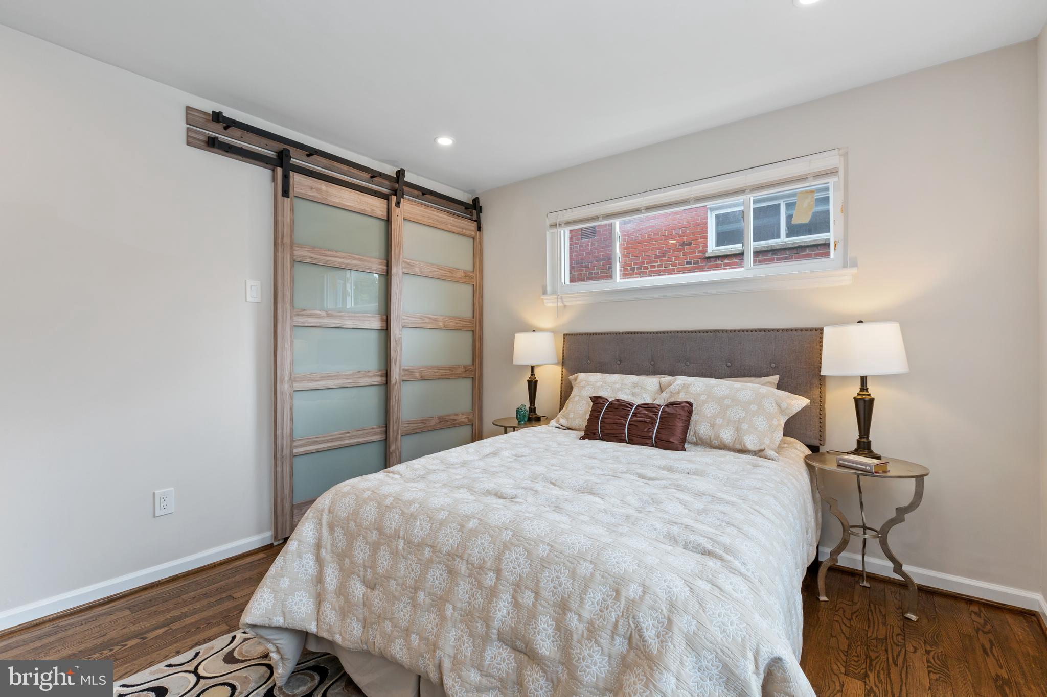 53 Victor Street Northeast, Unit 1 Washington, DC 20011 - Photo 15 of 18 a bedroom with a bed and a night stand