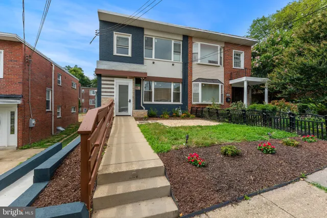 a front view of a house with a yard and potted plants