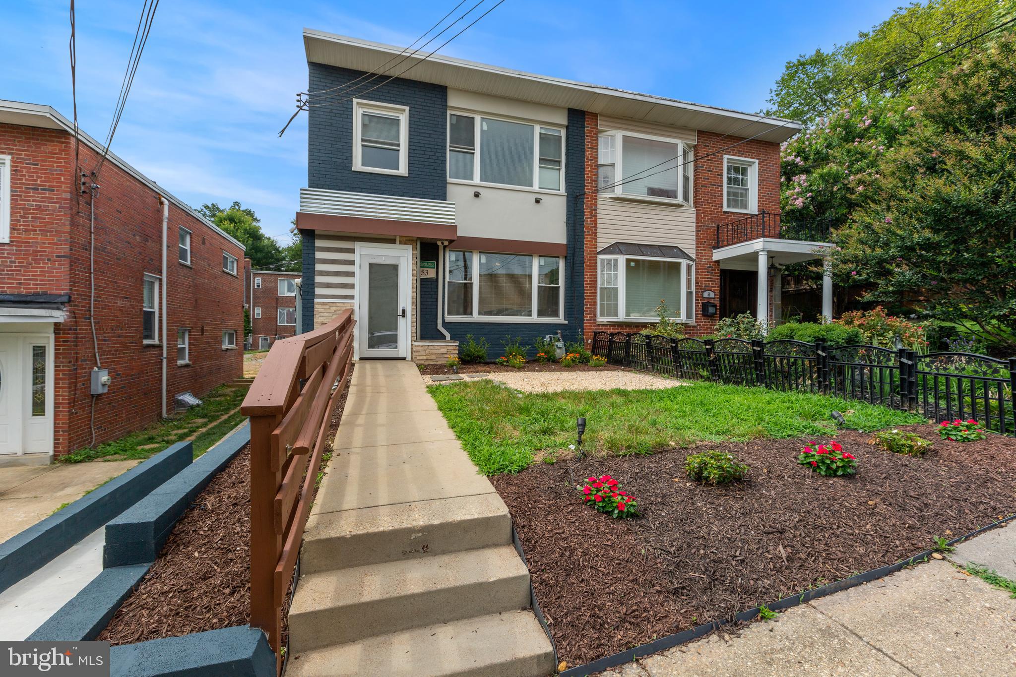 53 Victor Street Northeast, Unit 1 Washington, DC 20011 - Photo 2 of 18 a front view of a house with a yard and potted plants