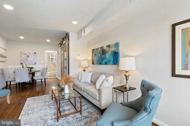 a living room with furniture a rug and a table