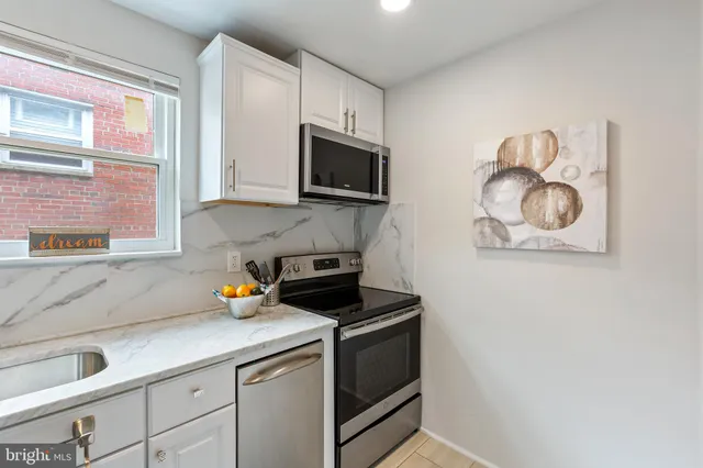 a kitchen with stainless steel appliances granite countertop a sink a stove and a microwave