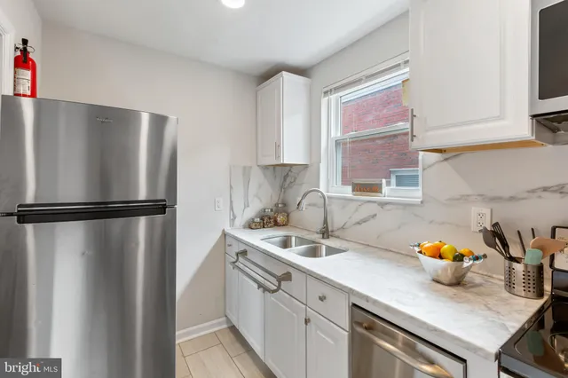 a kitchen with stainless steel appliances granite countertop a refrigerator and a sink