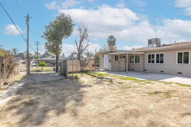a view of a house with a yard and sitting area
